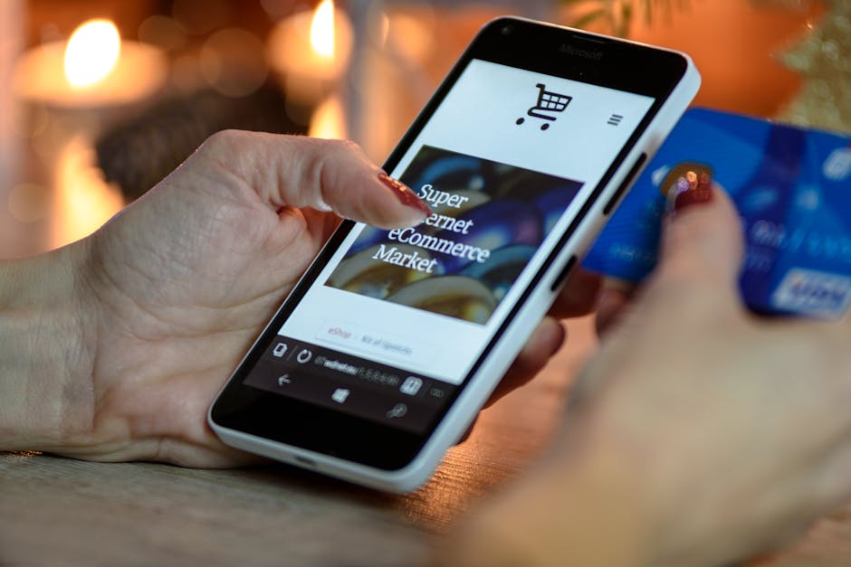 Woman using smartphone for online shopping with credit card in hand festive background lighting